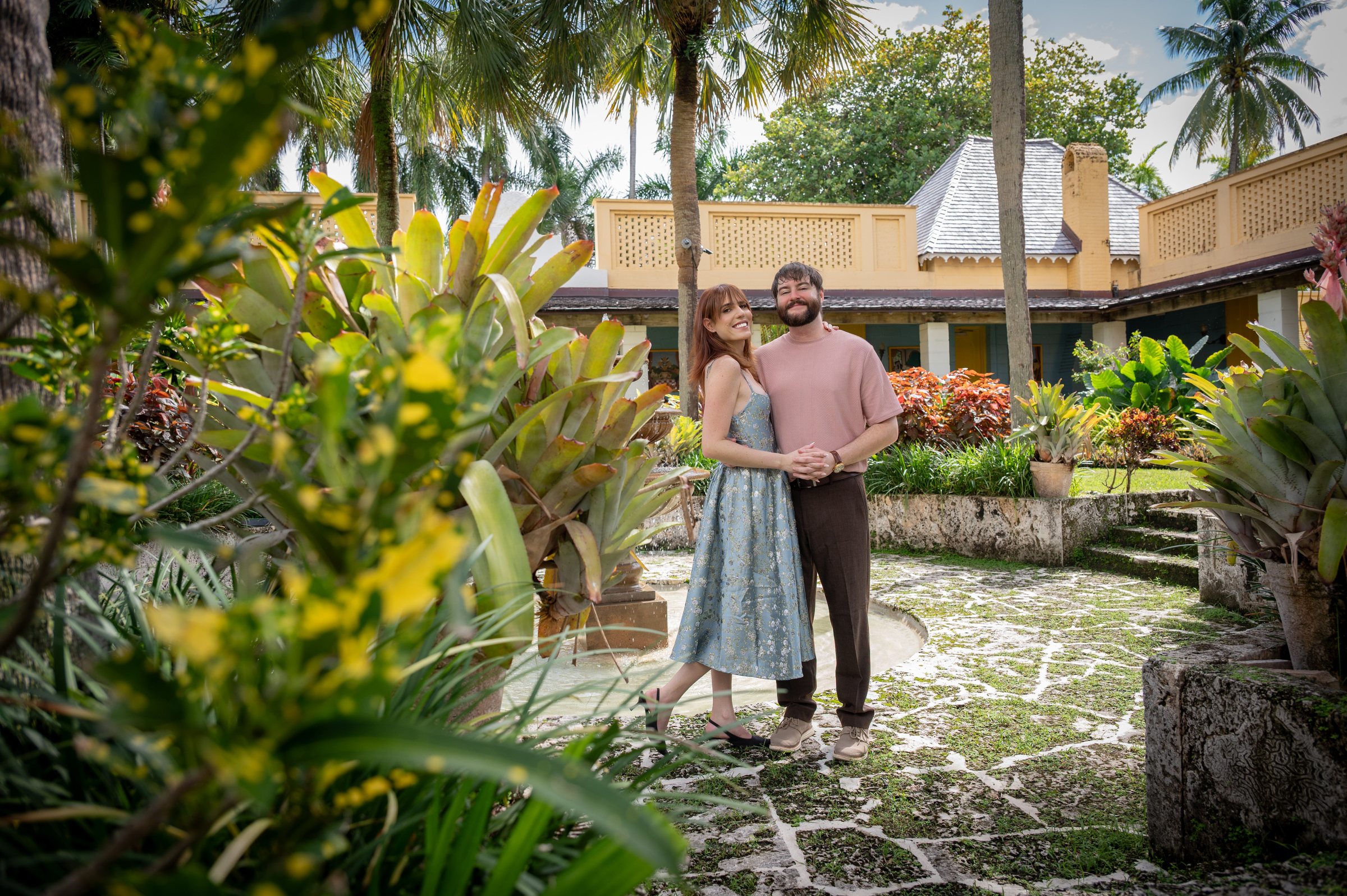 Connor and Alison standing together in the garden courtyard at Longan's Place