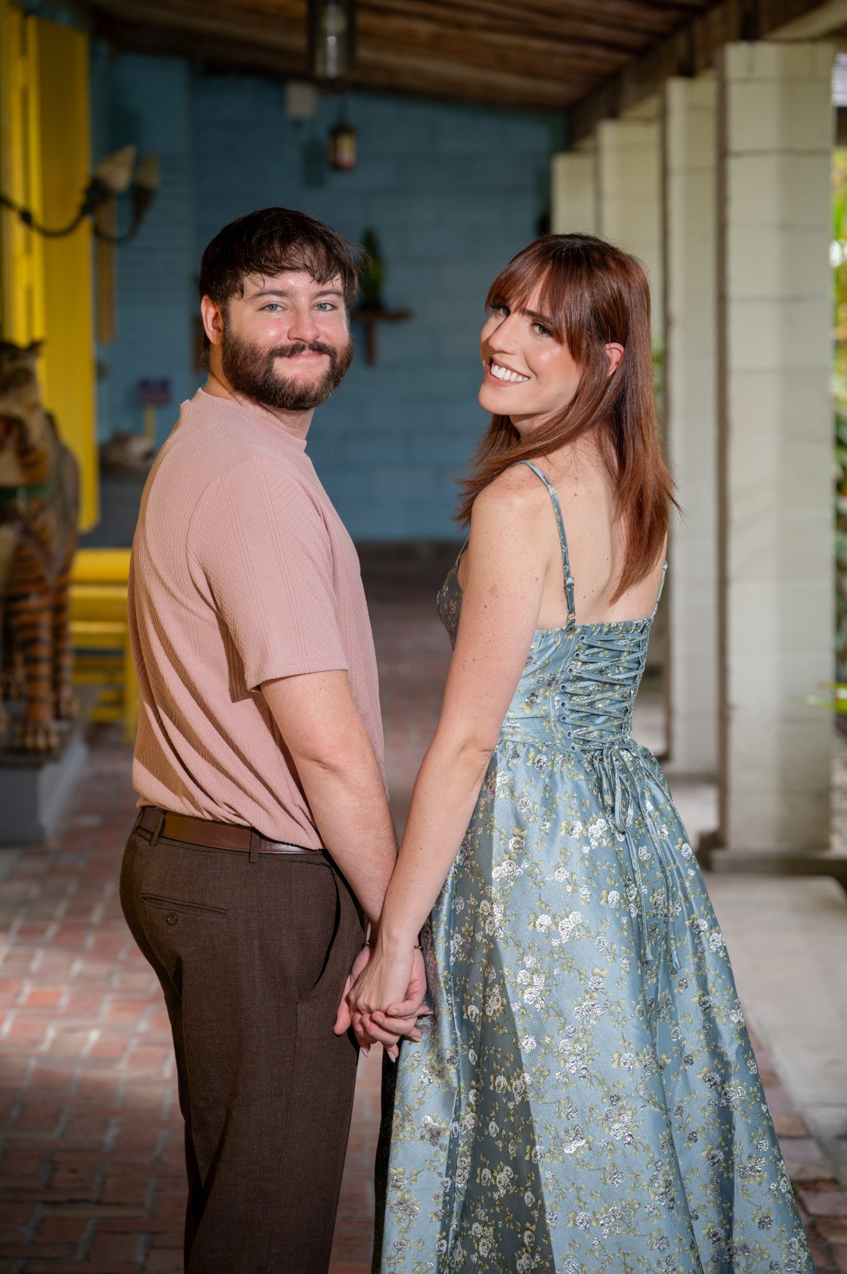 Connor and Alison holding hands and smiling back over their shoulders
