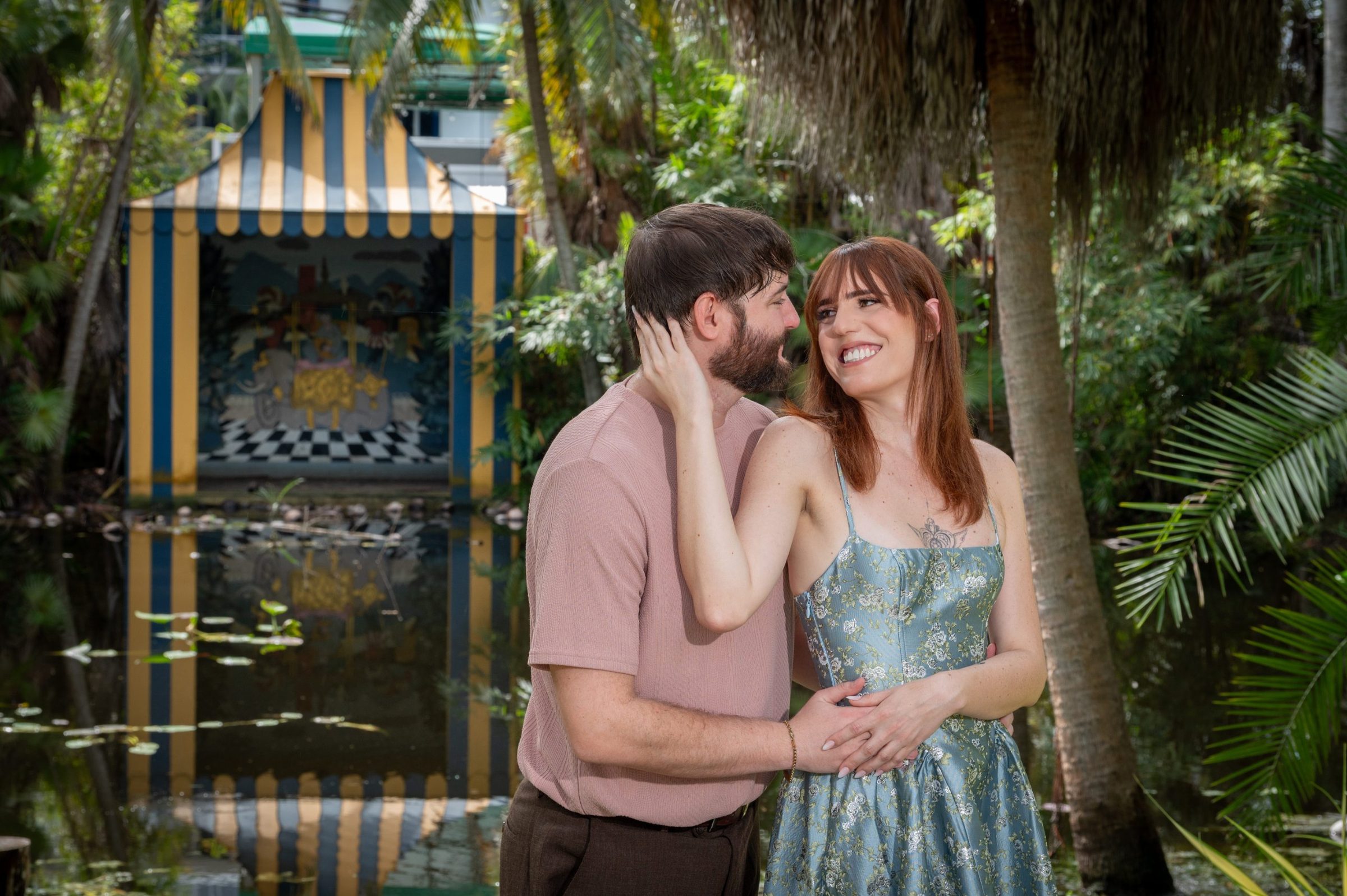Connor and Alison embracing beside a garden pond